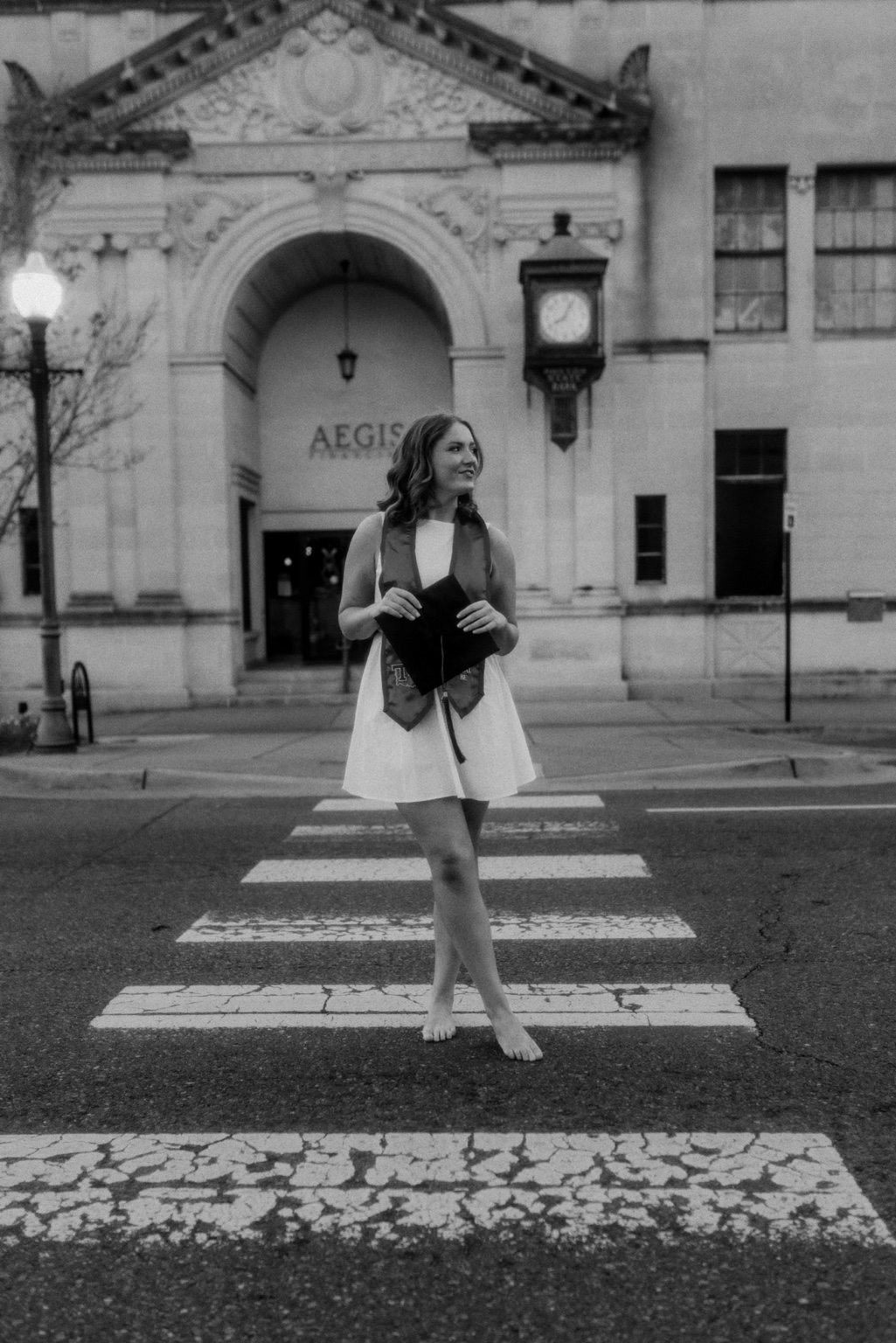 Black and white graduation portrait on a campus crosswalk
