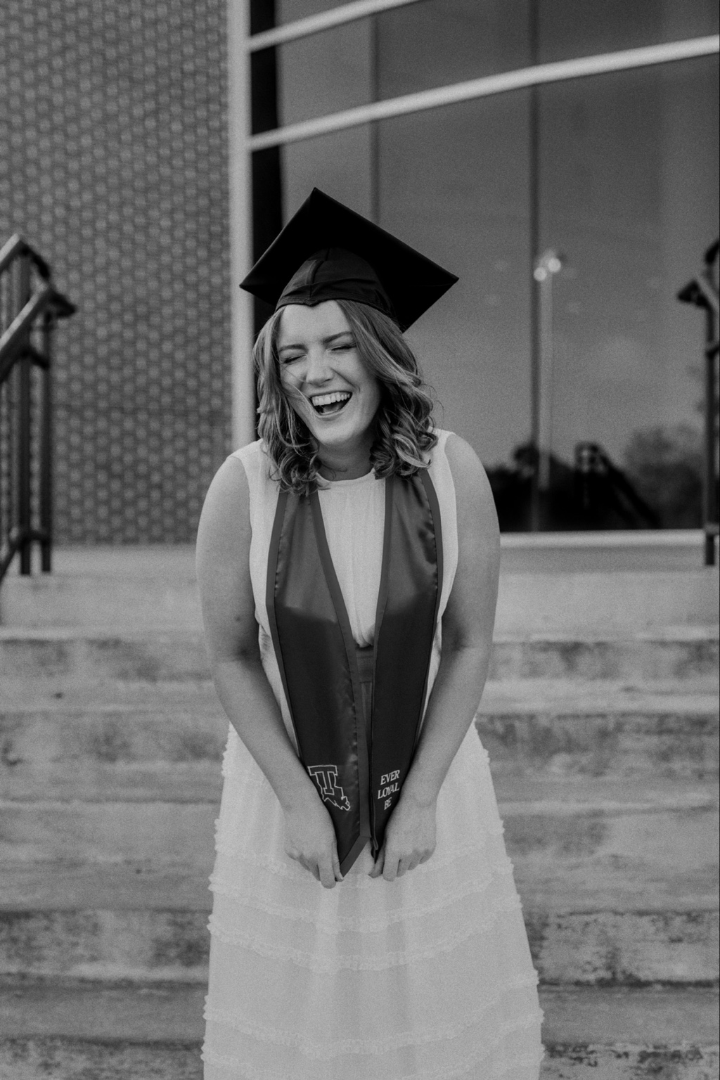 Black and white portrait of a laughing graduate
